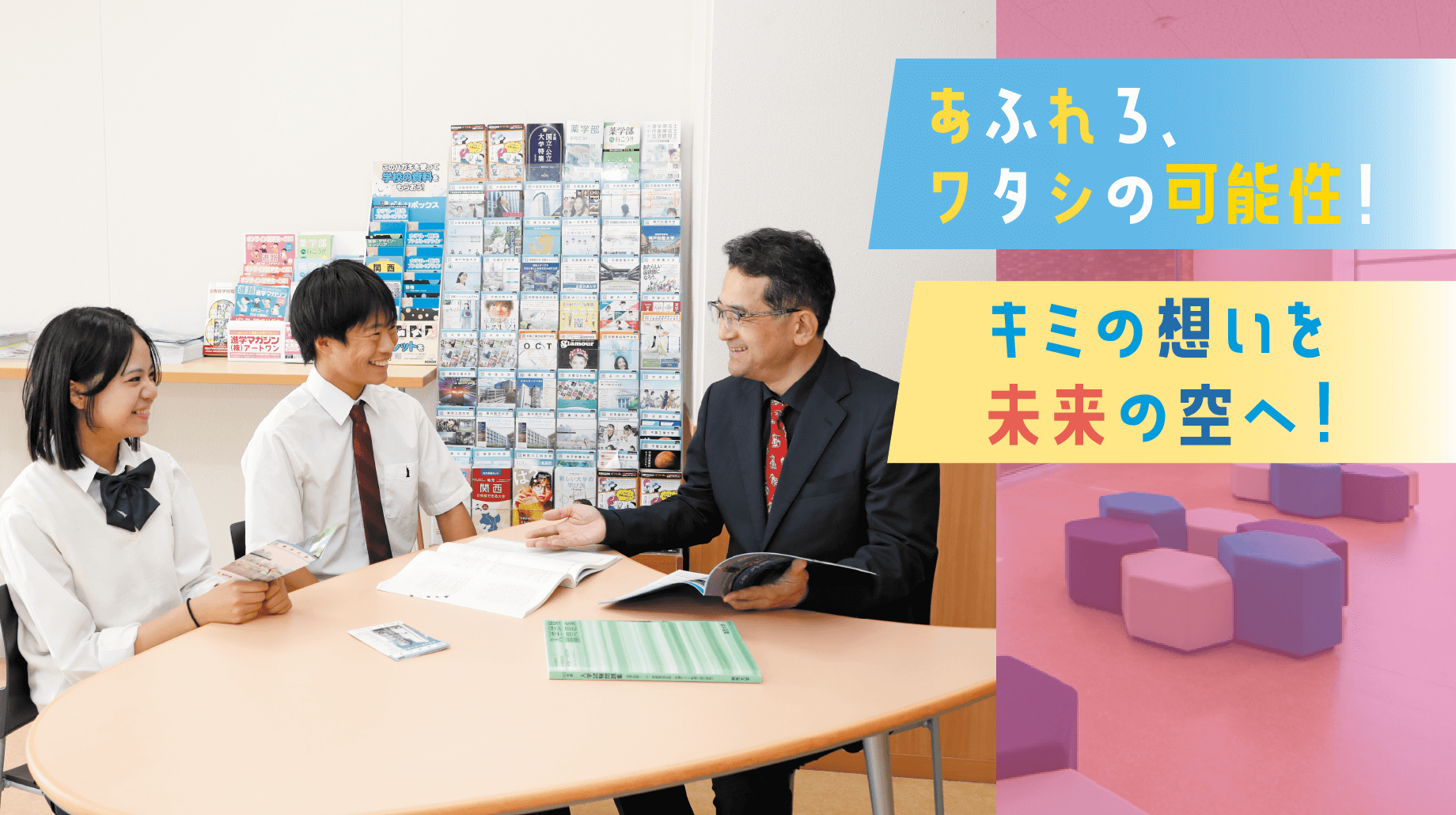 先生と生徒2人が机を囲み笑顔で話す様子